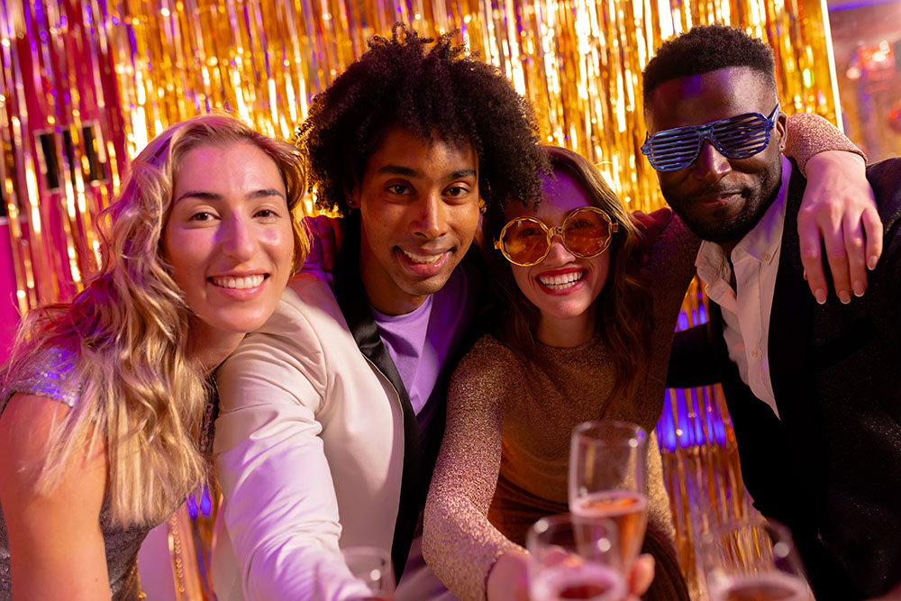 Four friends in vibrant sunglasses posing at the photo booth.